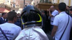 Crollo di Torre Annunziata, il pompiere indossa il casco per salutare le vittime